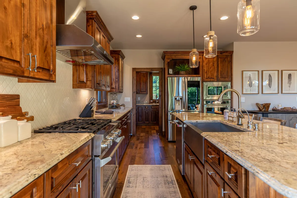 A bright, functional kitchen featuring granite countertops, stainless steel appliances, a kitchen island, and warm wood cabinets—perfect for preparing meals and entertaining.