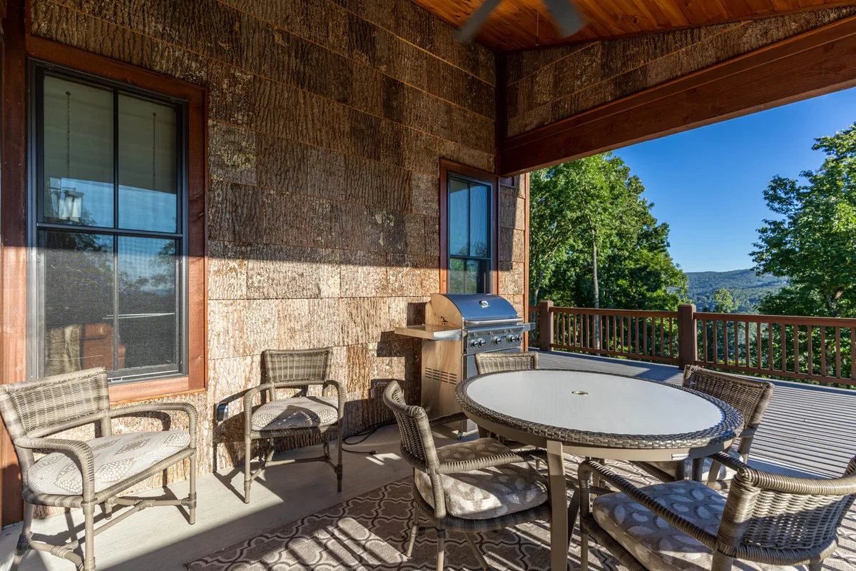 A welcoming outdoor dining area featuring a table set for a meal, a grill ready for barbecues, and views of the surrounding landscape. The scene evokes friendly gatherings, outdoor dining, and relaxation in a resort-like environment, hinting at the BBQ pavilions and open lawns mentioned in the content.
